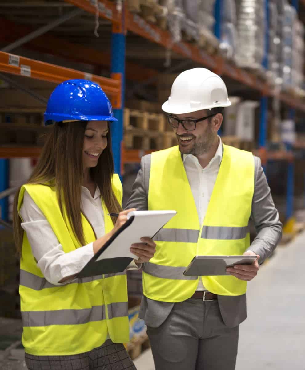 Two people in factory wearing hi-viz vests